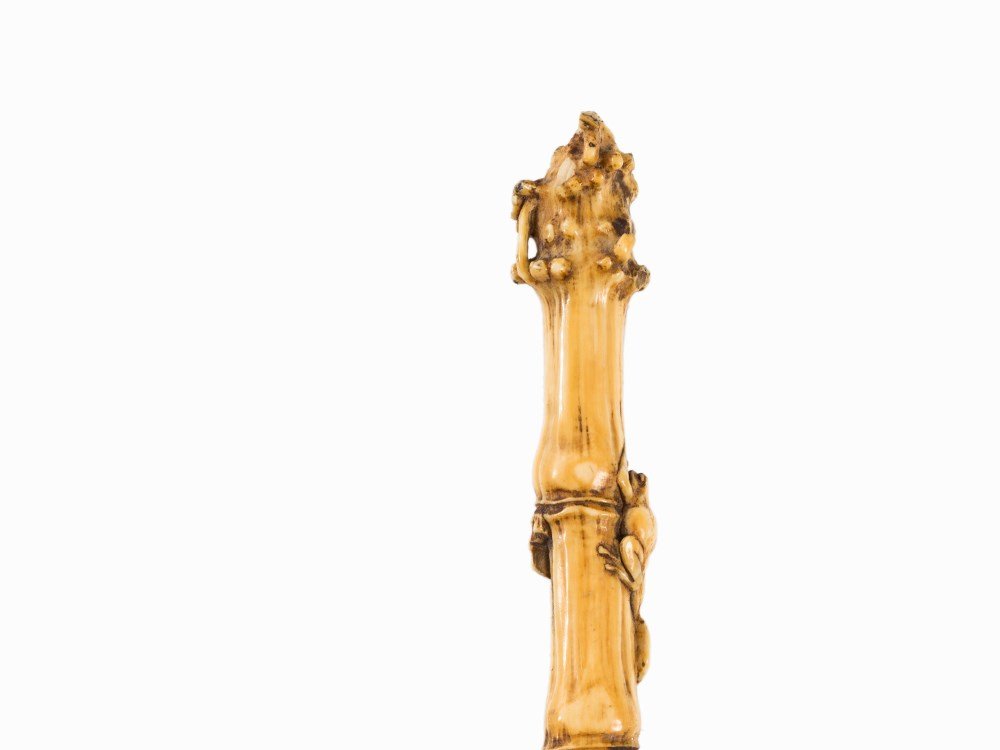 A Delicate Walking Cane with Carved Ivory Handle,: Silver (tested), ivory, carved, wood, ebonized Japan, c. 1900 Smooth, conical tapered shaft (presumably added later and repainted) Silver cuff with applied vine tendril décor Carved ivory handle scul