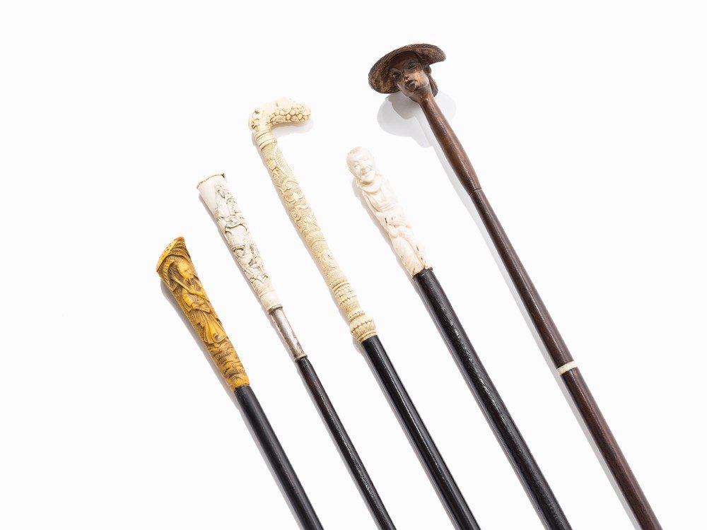 5 Walking Sticks with Exotic Carvings, 1st H. 20th C.: Ebonized wood and hardwood, carved ivory, yellow plastic Southeast Asia and France, first half of the 20th century Slender cylindrical shafts 2 handles with figurative motifs and landscape sceneries, 