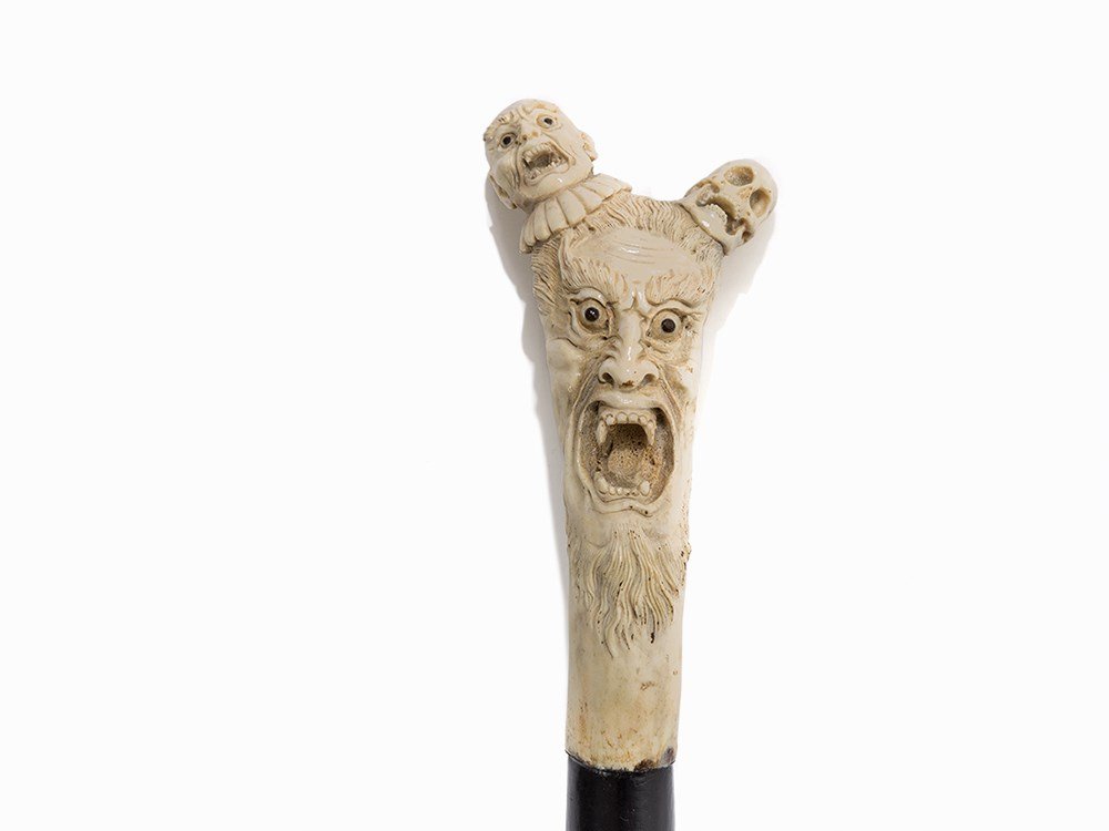 A Walking Cane with Figural Carved Handle, pres. Japan,: Horn, carved, wood, ebonized Presumably Japan, 19th century Conical tapered shaft made of wood Carved handle with the sculptural depiction of a mythical being, presumably of demon Oni, with skull and 