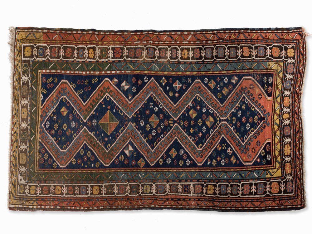 Bordjalou Rug, Caucasus, around 1960: Wool on cotton, in red, blue, yellow, brown, as well as beige and green Caucasus, around 1960 Knot density approx. 75,000 nodes per m² Style-typical patterned field with spreading flower décor Flora