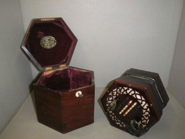 A Lachenal and Co. concertina with rosewood frette: A Lachenal and Co. concertina with rosewood fretted end plates, printed 39393 to the cotton panel below the end plate. 48 stained bone buttons, black leather and paper four fold bellows and a mahogany