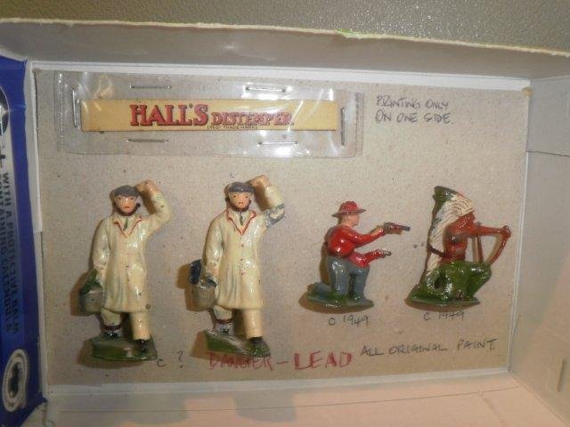 A pair of 'Halls Distemper' lead figures with boar: A pair of 'Halls Distemper' lead figures with board, one green brush, green tie, one black brush, black tie, original paint plus a cowboy, an Indian with bow (broken), both kneeling circa 1949, origin