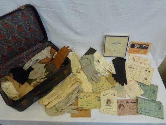 A suitcase of gloves and a box full of unopened hair: A suitcase of gloves and a box full of unopened hair nets in original packaging.