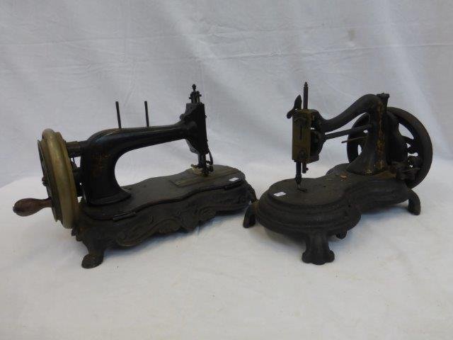 Two early cast iron sewing machines set on shaped: Two early cast iron sewing machines set on shaped bases.
