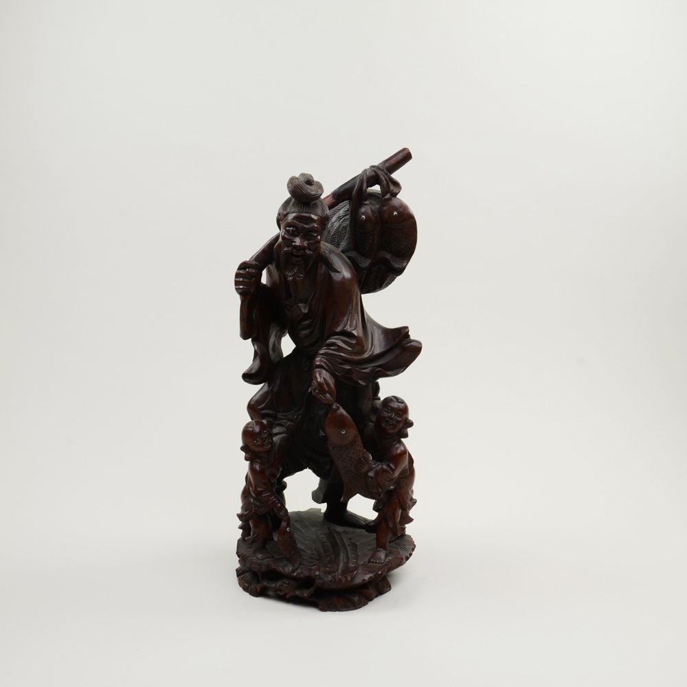 CARVED WOOD FISHERMAN WITH TWO CHILDREN: 老漁翁造像 Fisherman returning with fish and two children helping him carry the fish. Defect on the eyes. H: 16"