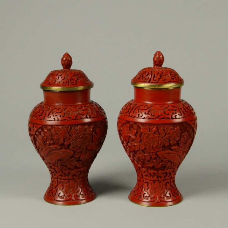 PAIR OF CARVED CINNABAR LACQUER JARS: Brass bodied. Double-sided panels with intricate floral designs. Blue glazed base and interior. H: 8"