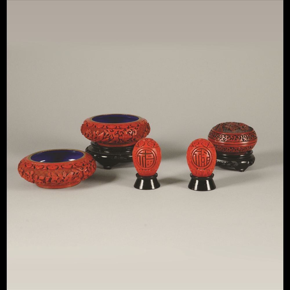 GROUP OF 5 CARVED CINNABAR PIECES: Bronze based. Consists of two ashtrays, one inkpad box, and a pair of eggs with Fu & Lu carved Chinese characters meaning luck & good fortune.