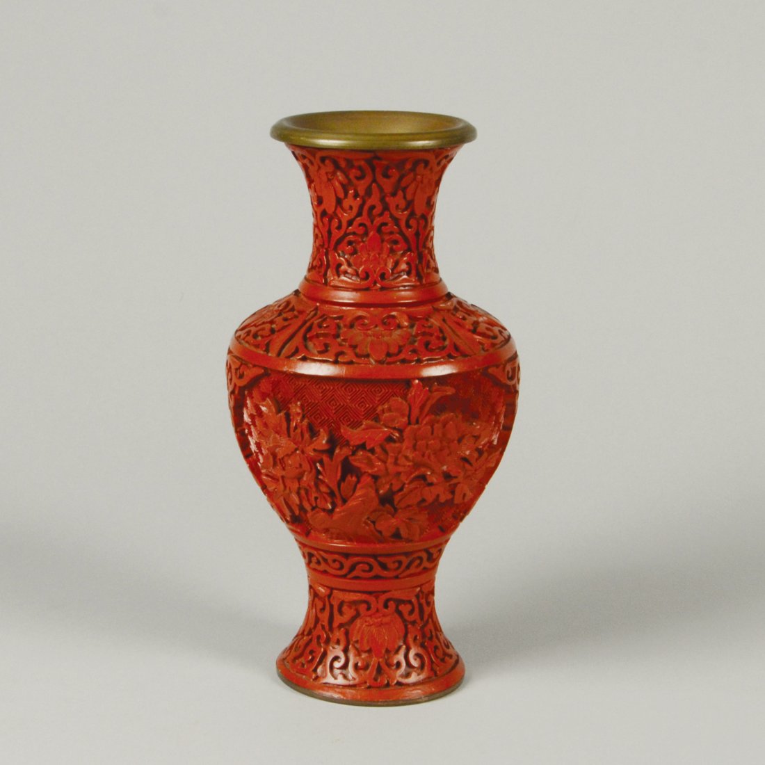 CARVED CINNABAR LACQUER VASE: Brass bodied. Double-sided panels with intricate floral designs. Blue glazed base and interior. H: 8"