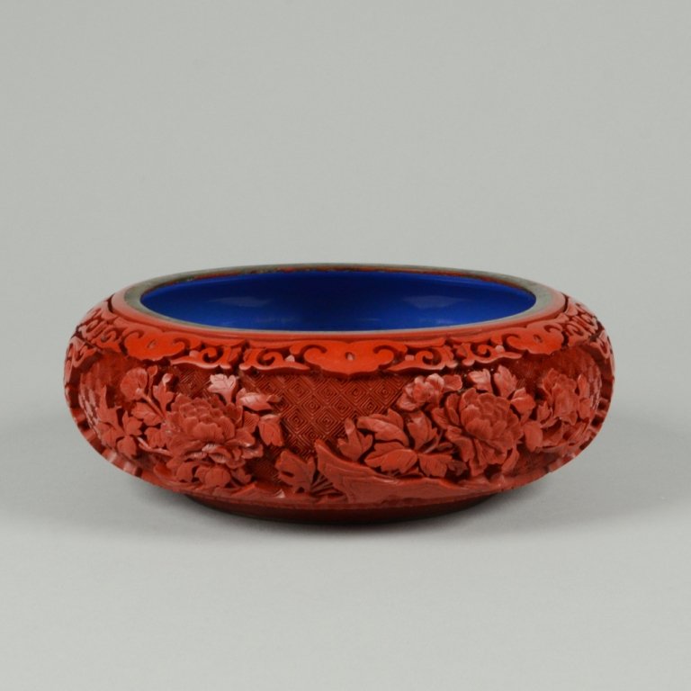 CARVED CINNABAR LACQUER WATER POT: Brass bodied. Double-sided panels with intricate floral designs. Blue glazed base and interior. D: 7 ½"