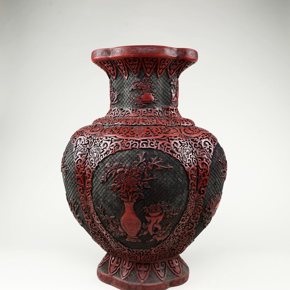 LARGE WOOD BASED CARVED CINNABAR LACQUER VASE: Cinnabar lacquer vase carved with lotus scroll designs. Four panels on vase body depicting the Eight Treasures design. Qing Dynasty Yongzheng mark. (W: 15" H: 22")