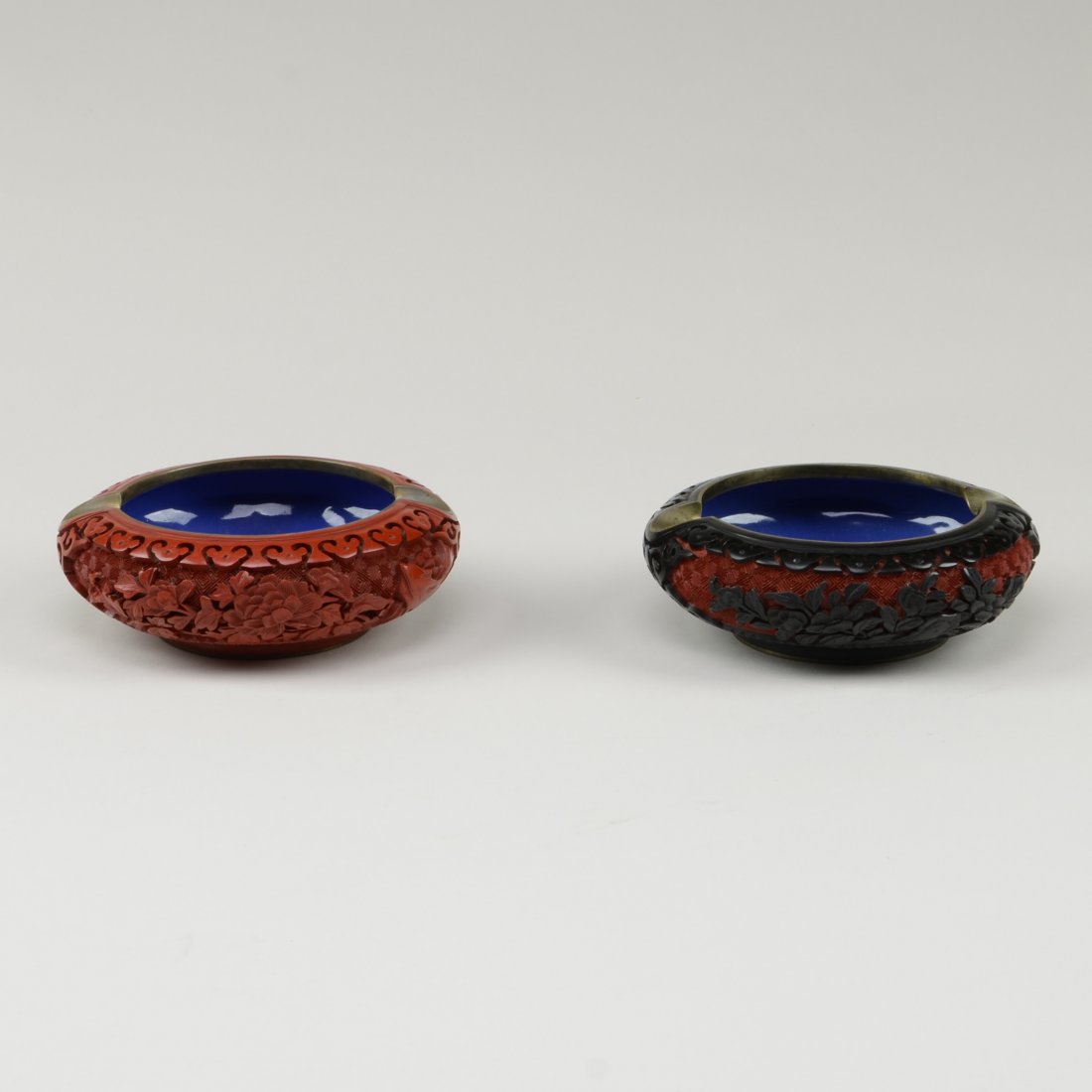 TWO CINNABAR LACQUER ASHTRAYS: Left: red lacquer. Right: black lacquer with red ground. (D: 5" Wt: 14 oz)