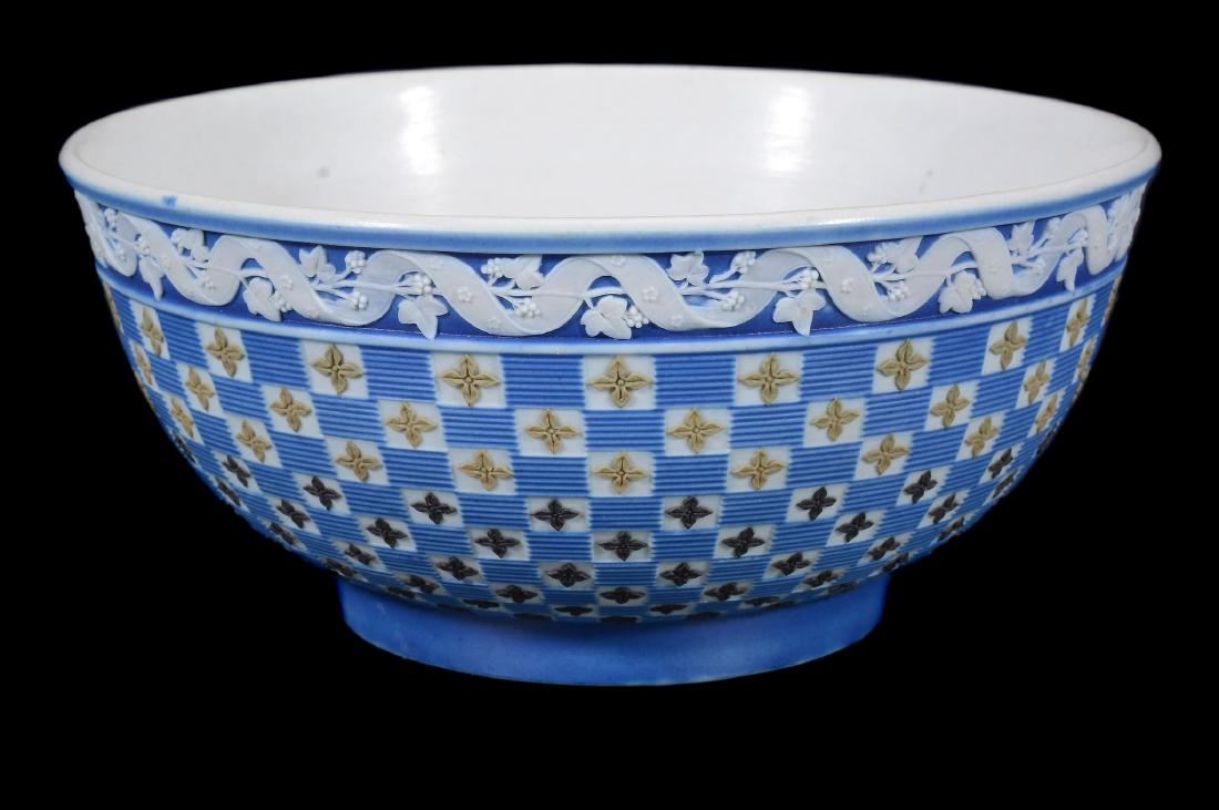 A Wedgwood four-colour jasper 'diced' slop bowl from a: A Wedgwood four-colour jasper 'diced' slop bowl from a solitaire dejeurner set, circa 1790, decorated with a chequer pattern of quatrefoils beneath an ivy and ribbon border, the interior lapidary poli