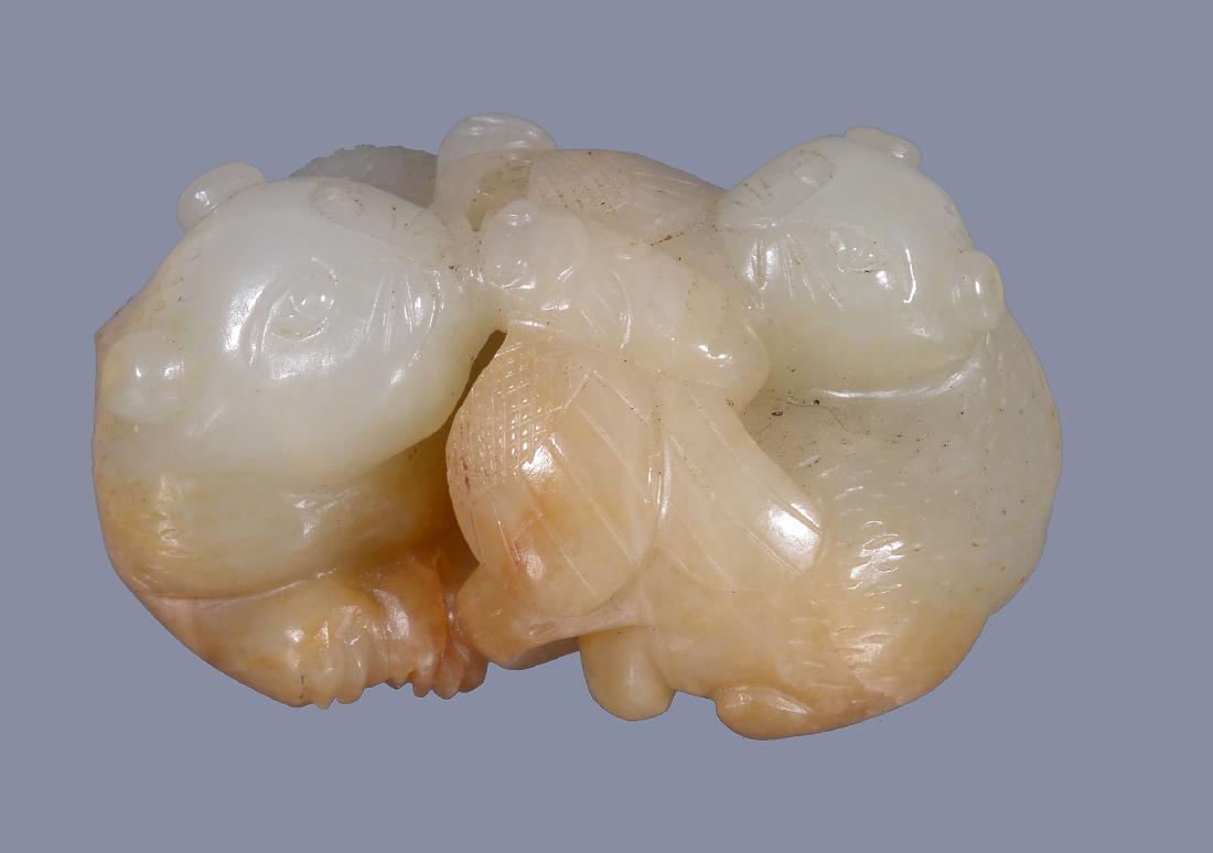 A Chinese pale celadon and brown jade group of (1 of 4)