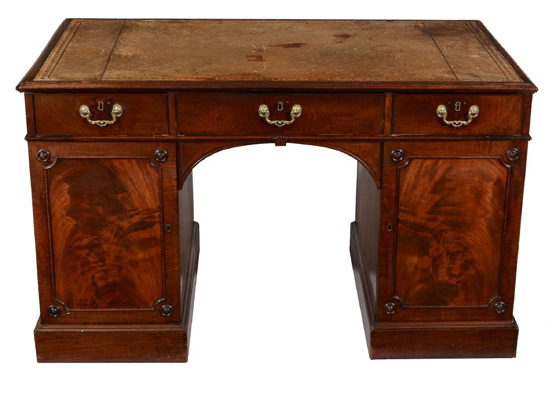A George III mahogany pedestal desk, circa 1770: A George III mahogany pedestal desk, circa 1770, in the manner of Thomas Chippendale, the rectangular tooled leather inset top with moulded edge above three frieze drawers and panelled doors with roun