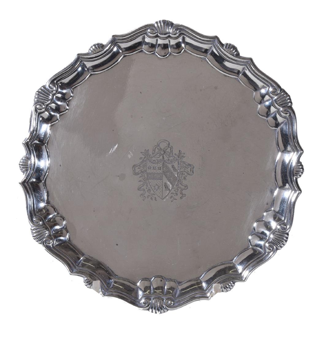 A George II silver shaped circular salver by Robert: A George II silver shaped circular salver by Robert Abercromby, London 1742, with a raised moulded shell and scroll border, engraved with an armorial, on three hoof feet, 21cm (8 1/4in) diameter, 402g