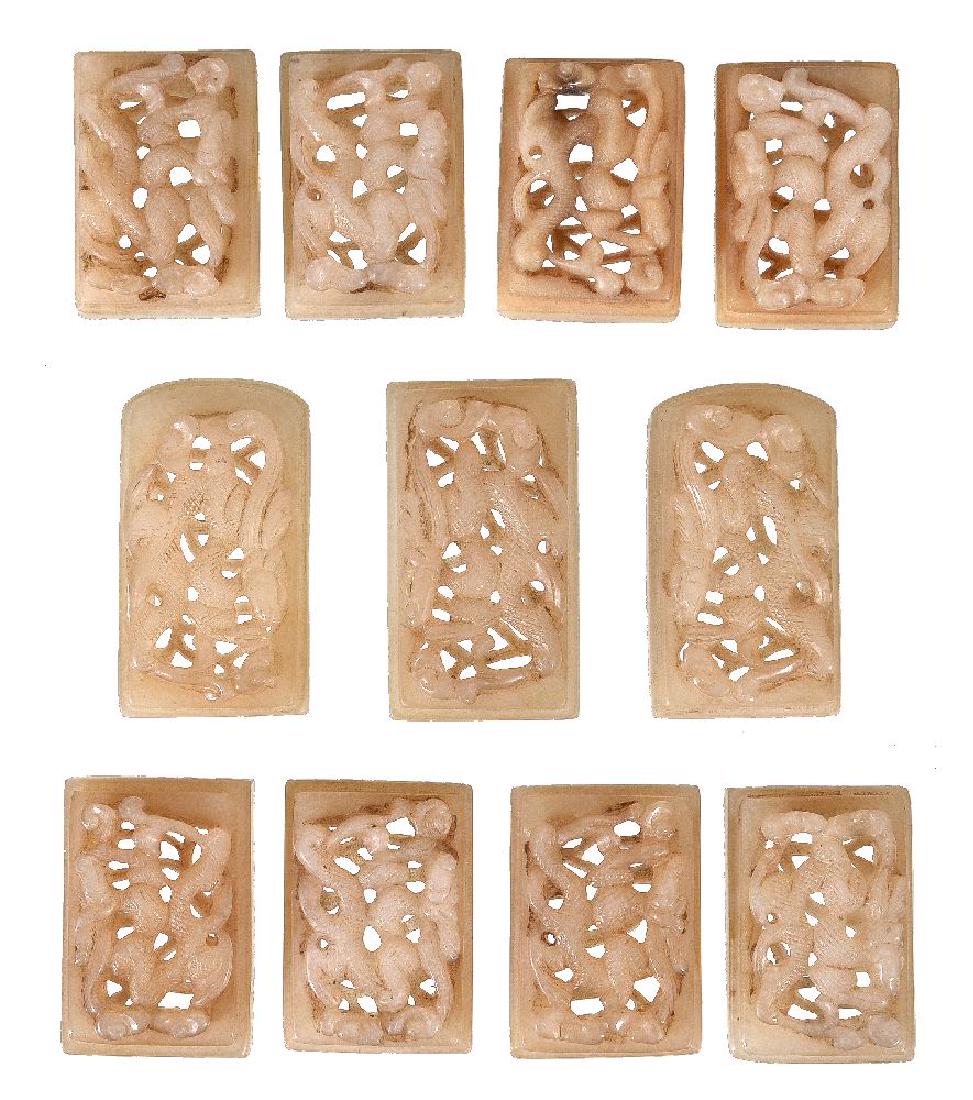 A set of eleven Chinese white and brown pierced jade (1 of 2)