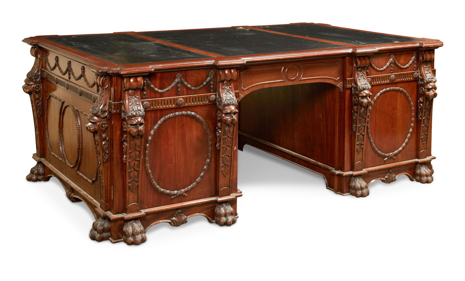 A CARVED MAHOGANY TWIN PEDESTAL PARTNERS DESK, IN: A CARVED MAHOGANY TWIN PEDESTAL PARTNERS DESKIN GEORGE III STYLE, LATE 19TH/EARLY 20TH CENTURYAfter the design by Thomas Chippendale for Nostell Priory, the rectangular top with a green tooled leather