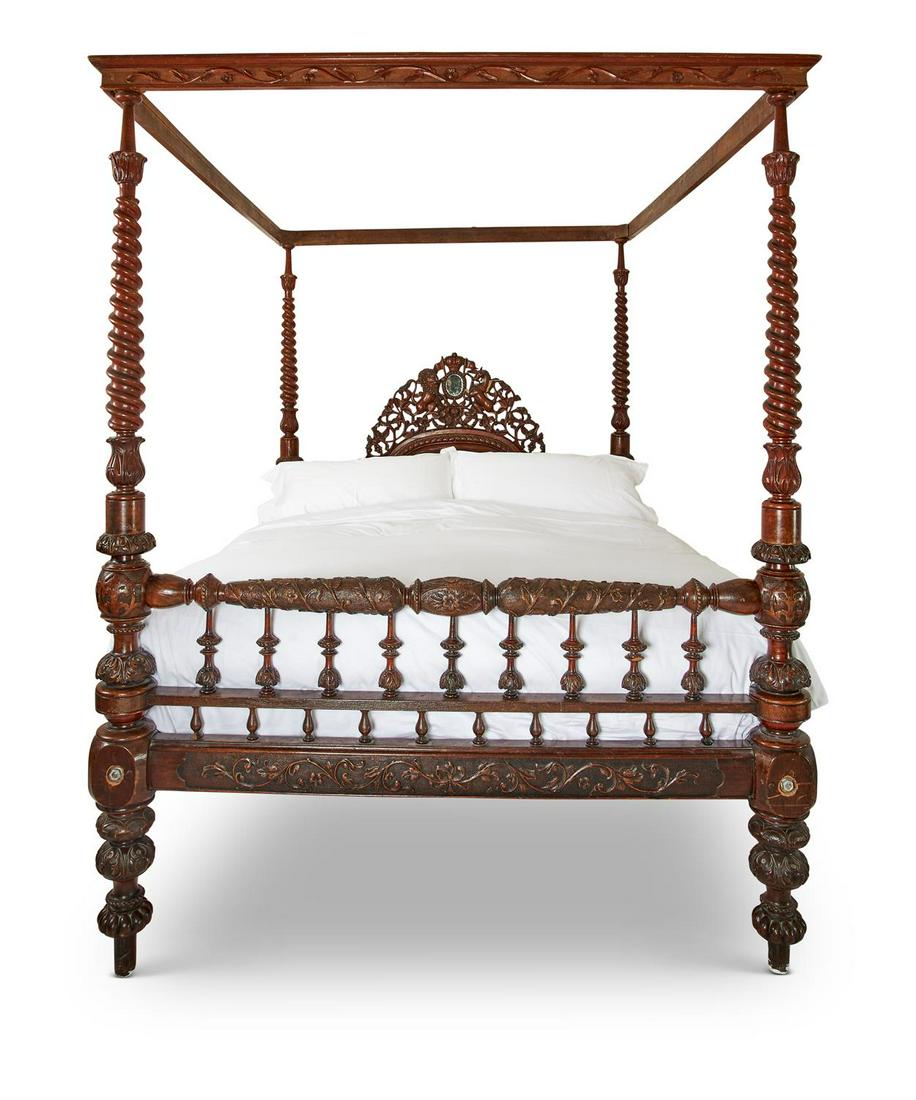 A LARGE CARVED MIXED WOOD FOUR POSTER BED, MID 19TH: A LARGE CARVED MIXED WOOD FOUR POSTER BEDMID 19TH CENTURYThe rectangular canopy rails supported on spiral turned and baluster posts with carved headboard and spindle footboard232cm high, 230cm long, 1