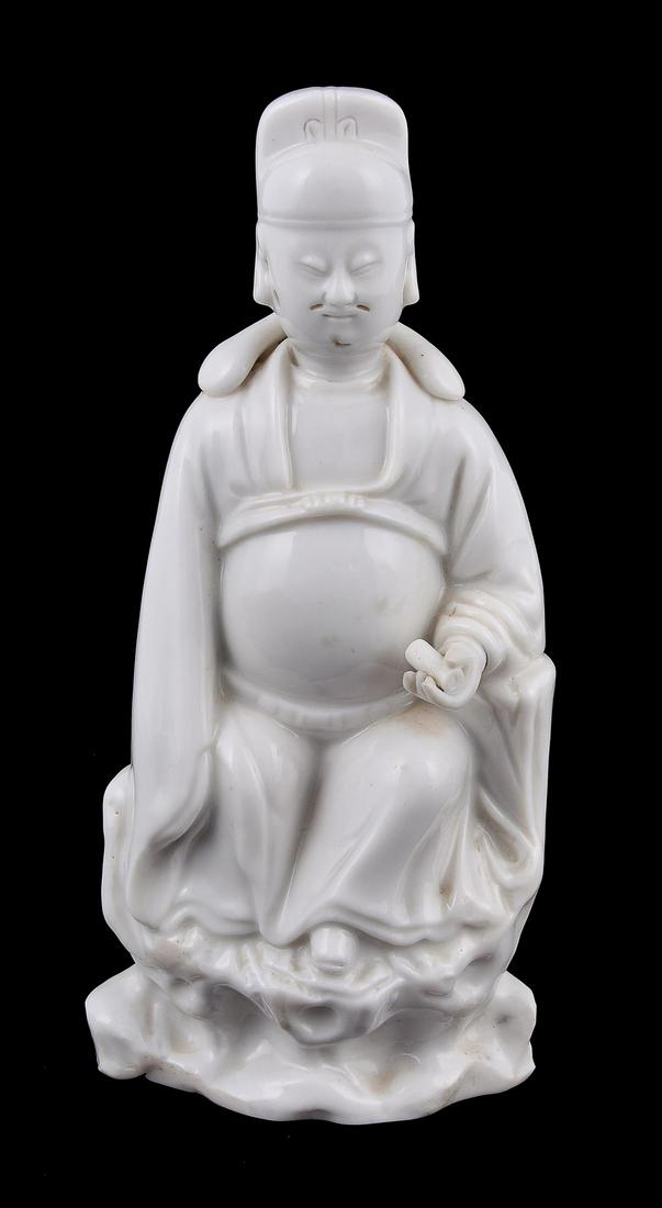 A Dehua seated figure of Wenchang: A Dehua seated figure of Wenchang, 17th century, the Daoist God of Literature seated on a pierced rocky ledge, wearing a long, belted robe and an official's hat, and holding a scroll in his left hand,