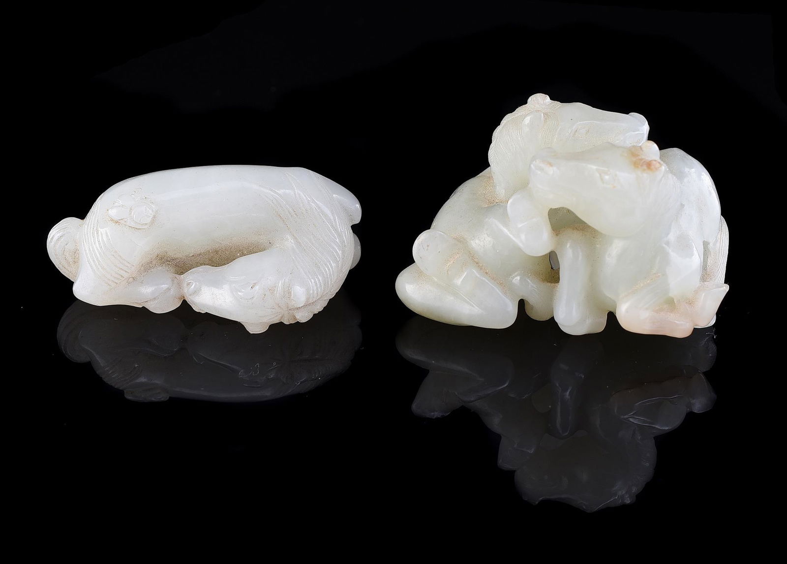 A Chinese small white jade model of a recumbent 'horse' (1 of 4)