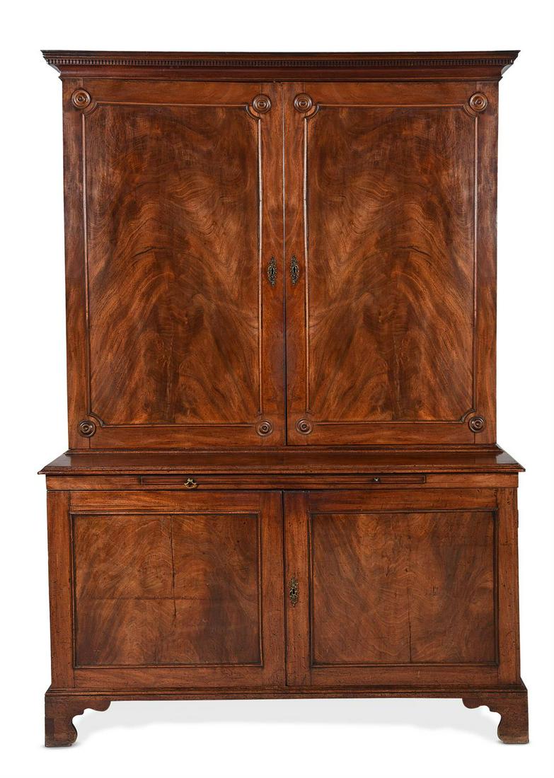 A GEORGE III MAHOGANY BOOKCASE CABINET, IN THE MANNER OF THOMAS CHIPPENDALE, CIRCA 1770: A GEORGE III MAHOGANY BOOKCASE CABINET IN THE MANNER OF THOMAS CHIPPENDALE, CIRCA 1770The moulded upper doors opening to two banks of four adjustable shelves, the lower section with a slide above a pa