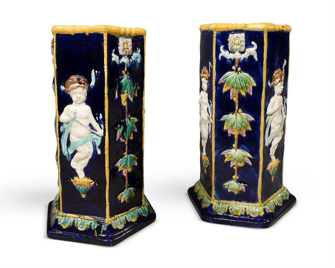 A PAIR OF MAJOLICA STICK STANDS, LATE 19TH CENTURY: A PAIR OF MAJOLICA STICK STANDS LATE 19TH CENTURY Hexagonal bodies with decoration of Cupid and floral trailing stems 53.5cm highProvenance:Barnwell Manor, NorthamptonshireWindsor House Antiques