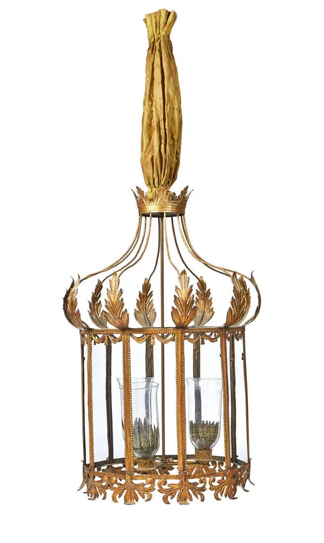 A PRESSED GILT METAL TEN GLASS LANTERN IN THE REGENCY STYLE, 20TH CENTURY: A PRESSED GILT METAL TEN GLASS LANTERN IN THE REGENCY STYLE DESIGNED BY OLIVER MESSEL With chamfered cresting and apron, with storm shades, fitted for electricity approximately 97cm high, 55cm wide Pr