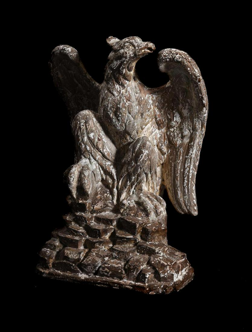 A LARGE CARVED AND PAINTED FIGURE OF AN EAGLE, IN THE MANNER OF WILLIAM KENT: A LARGE CARVED AND PAINTED FIGURE OF AN EAGLE IN THE MANNER OF WILLIAM KENT, SECOND QUARTER 18TH CENTURY Depicted seated on naturalistic rockwork base 62cm high, the base 40cm wideProvenance: Property