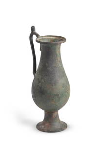 A BYZANTINE BRONZE EWER, CIRCA 8TH-12TH CENTURY A.D.: A BYZANTINE BRONZE EWER CIRCA 8TH-12TH CENTURY A.D. Set on a high flared foot, the slender body with rounded base and a widened mouth with upturned rim, the applied handle with a protruding thumb