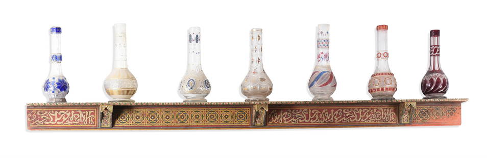 A POLYCHROME DECORATED SHELF MOROCCAN: A POLYCHROME DECORATED SHELF MOROCCAN, 19TH CENTURY11cm high, 179cm wide, 9cm deepTogether with seven 19th century narghile bottles, mostly Bohemian coloured flash glass produced for the Ottoman marke