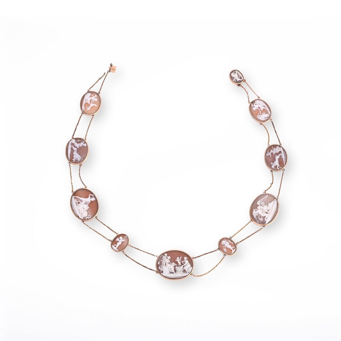 AN ITALIAN SHELL CAMEO NECKLACE: AN ITALIAN SHELL CAMEO NECKLACE CIRCA 1830sThe graduated shell panels carved primarily with Cupid as a main theme, including a woman selling cupids, based upon a fresco discovered in Pompeii in 1759,