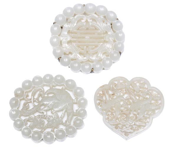 Three Chinese white jade openwork small plaques, c: Three Chinese white jade openwork small plaques, comprising a ruyi head form enclosing two flying cranes amongs ruyi clouds, Ming or earlier; an oval form enclosing a flying bird above blosso