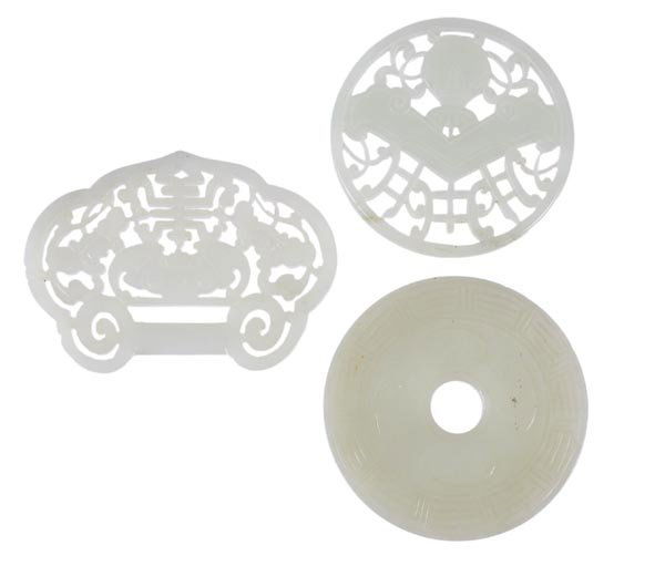 A Chinese jade plaque of circular form with a musi: A Chinese jade plaque of circular form with a musical chime above a vase, 5.4cm diameter; a jade carving in the form of a miniature bi disc, 5.8cm diameter; a jade plaque of ruyi form pierced
