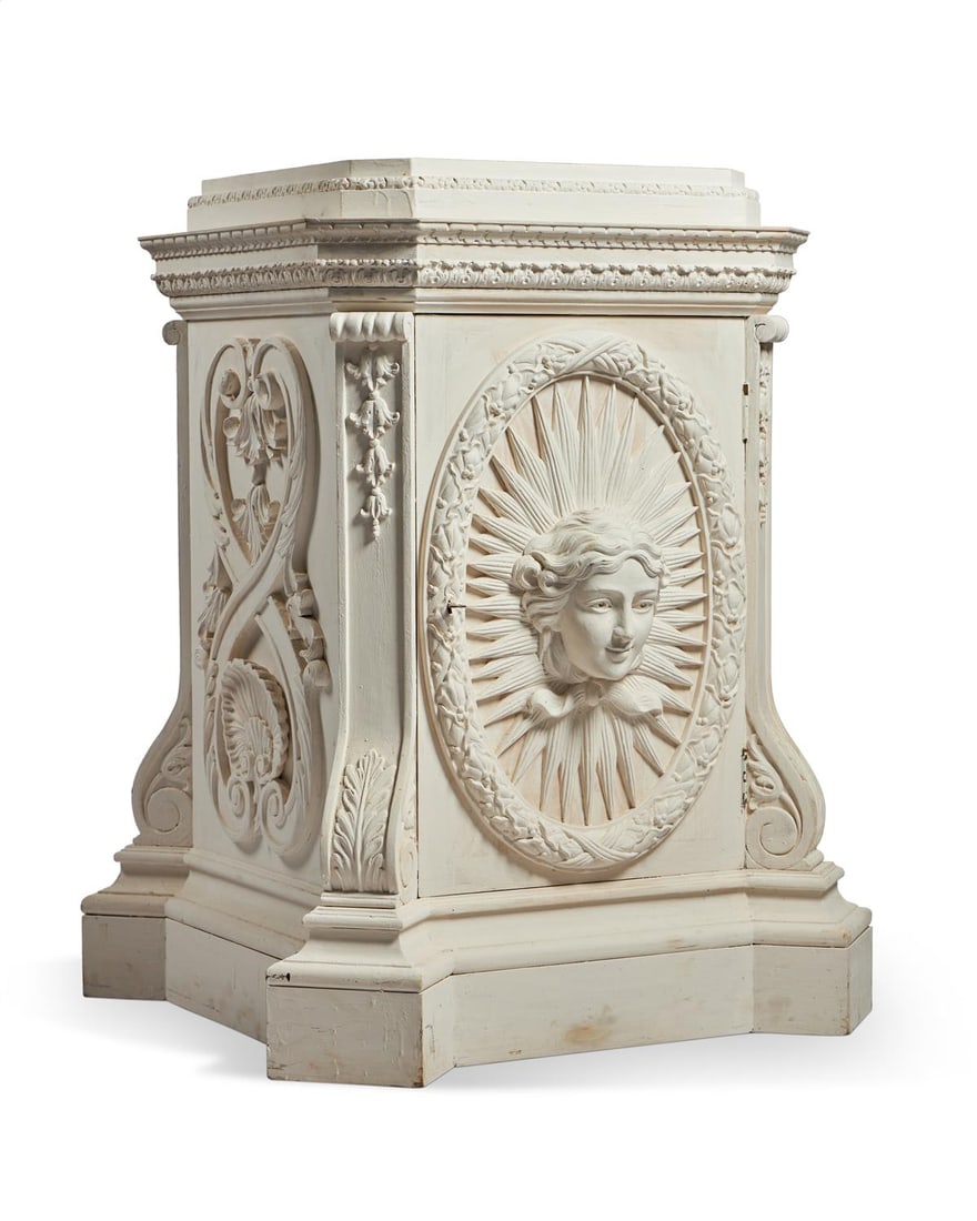 A WHITE PAINTED CARVED WOOD 'APOLLO' PEDESTAL, MODERN: A WHITE PAINTED CARVED WOOD 'APOLLO' PEDESTALMODERN, BY A MODERN GRAND TOUR, AFTER WILLIAM KENT Fitted with a door 100cm high, 67cm square
