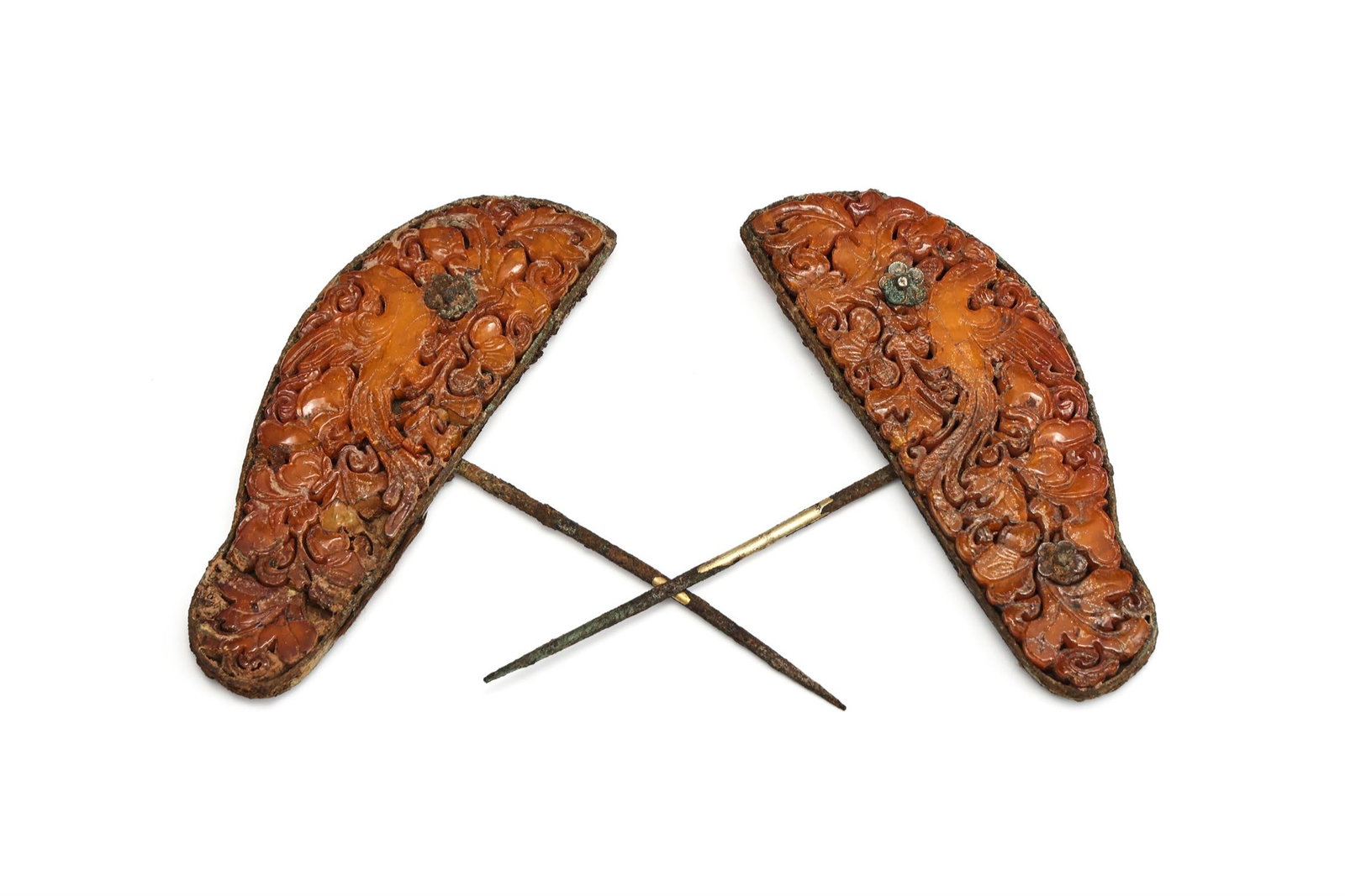 A pair of Chinese gilt and amber embellished hairpins: A pair of Chinese gilt and amber embellished hairpins, Ming Dynasty, the amber plaque carved in openwork with phoenix in flight amidst flowering foliage, 8.5cm wide (2)Provenance:Private CollectionPle