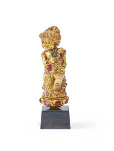 A Balinese gem-set gold coloured chased kris hilt: A Balinese gem-set gold coloured chased kris hilt, late 19th century, chased gold sheet over resin, with corundum and paste stones, 13.3ch high Provenance:Private Collection