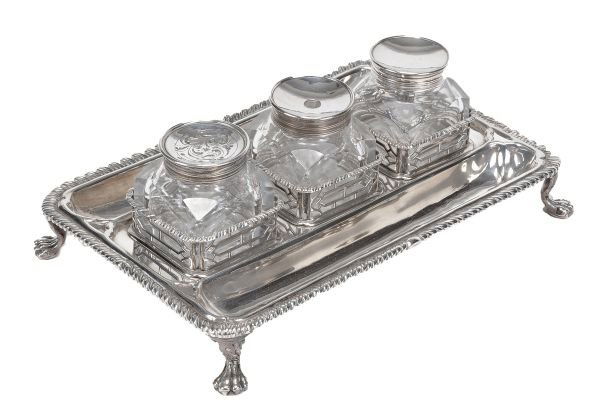 An early George III silver oblong three bottle ink: An early George III silver oblong three bottle inkstand by Edward Aldridge, London 1764, the three cut glass cube wells in pierced galleries, gadrooned rims, two pen wells and on four paw feet, engrav