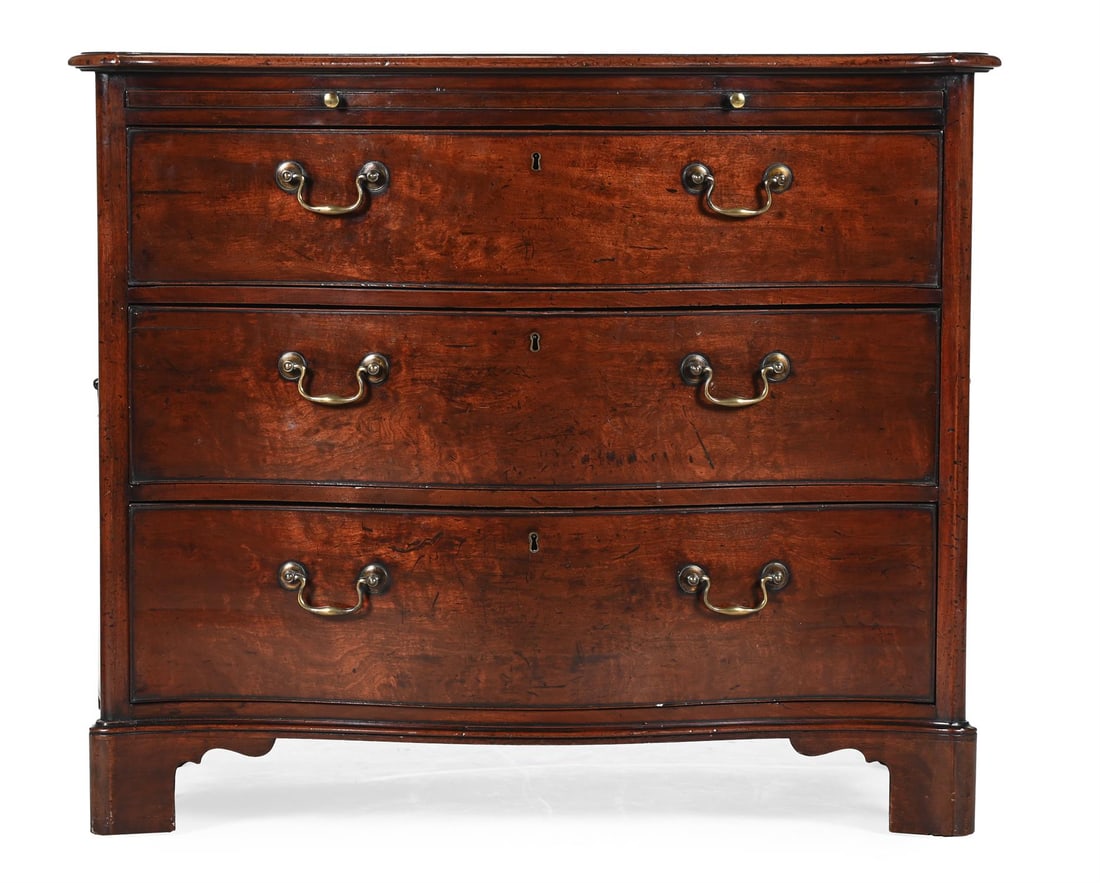 A GEORGE III MAHOGANY SERPENTINE COMMODE, IN THE MANNER OF THOMAS CHIPPENDALE, CIRCA 1770: A GEORGE III MAHOGANY SERPENTINE COMMODE IN THE MANNER OF THOMAS CHIPPENDALE, CIRCA 1770 With brushing slide, the back and underside with red wash, the feet blocks of laminated construction86cm high,