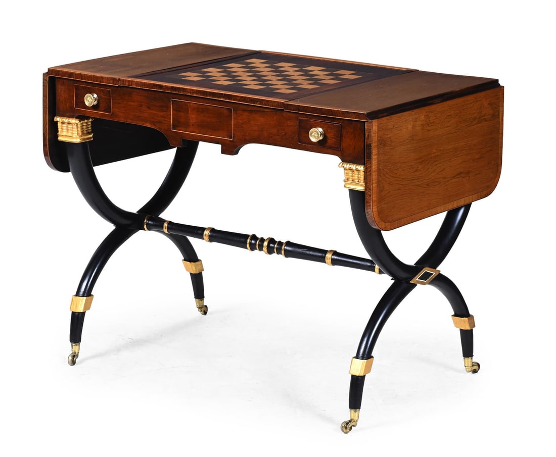 Y A REGENCY ROSEWOOD, BRONZED AND PARCEL GILT DECORATED GAMES TABLE, CIRCA 1805: Y A REGENCY ROSEWOOD, BRONZED AND PARCEL GILT DECORATED GAMES TABLEATTRIBUTED TO JOHN MCLEAN, CIRCA 1805 The sliding panel to the top with parquetry chess board to one side, the recess beneath with gi