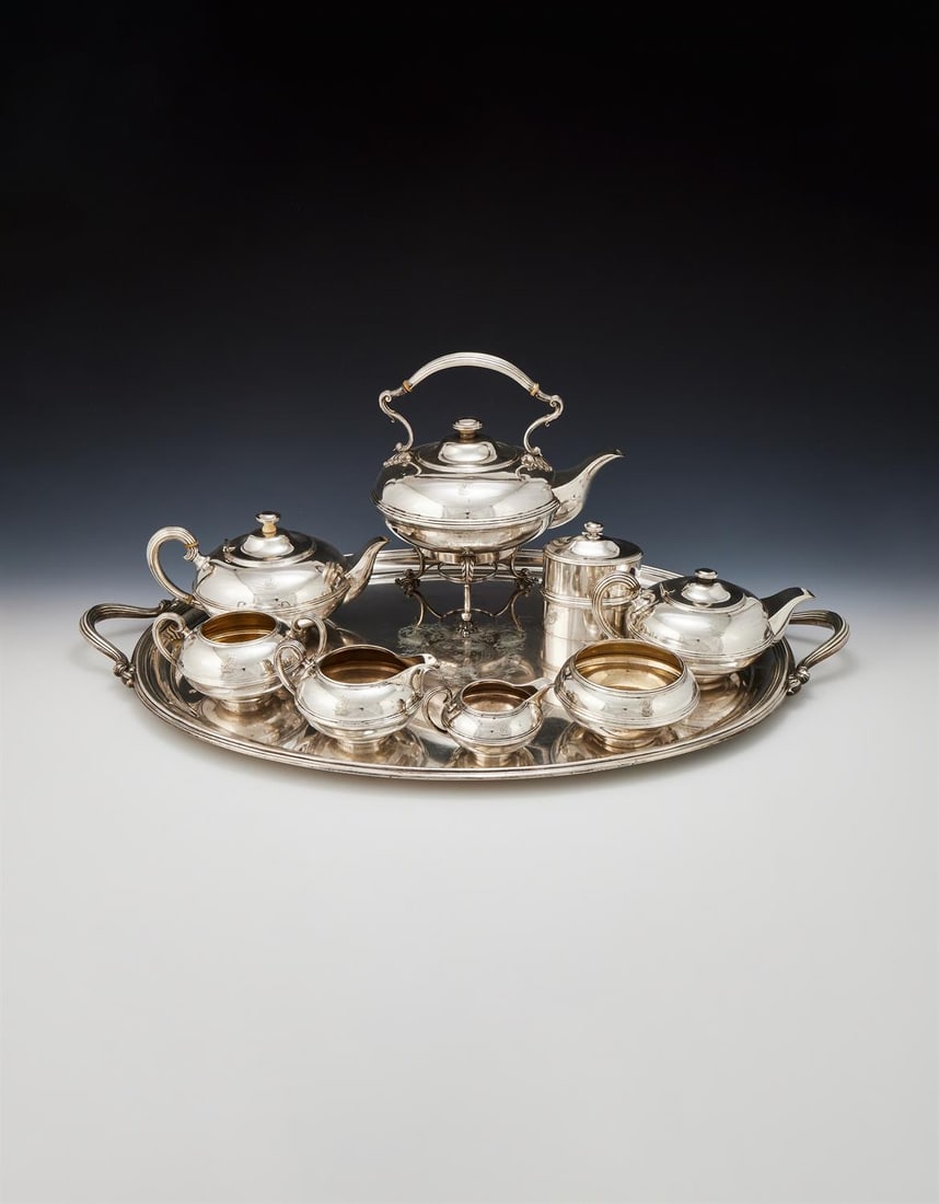 Y A SILVER NINE PIECE SILVER TEA SET: Y A SILVER NINE PIECE SILVER TEA SETGARRARD & CO., LONDON 1919Comprising: a kettle on stand, two tea pots, a milk jug, a cream jug, a twin handled sugar bowl, a slop bowl and a tea caddyThe kettle on