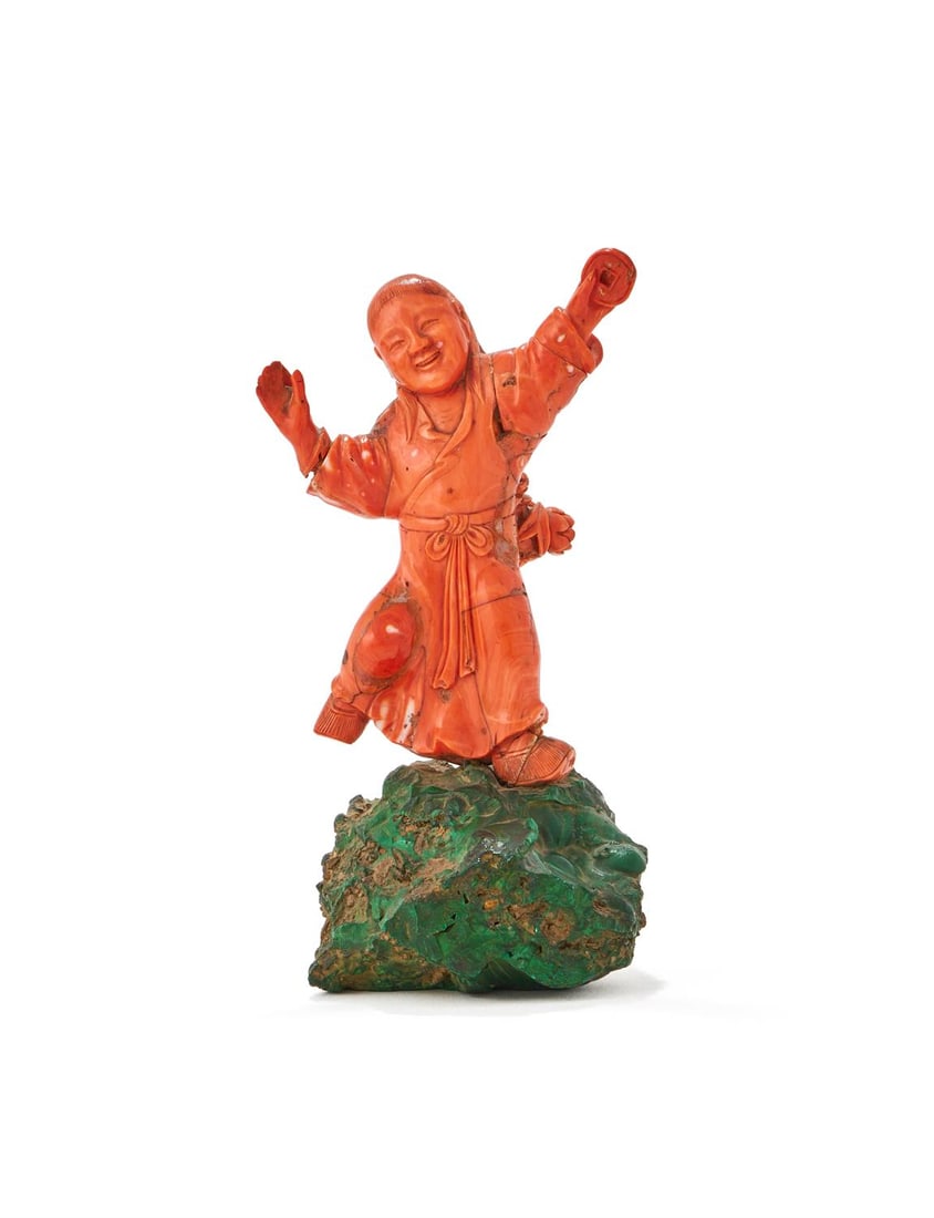 Y A Chinese coral malachite-mounted figure of Liu Hai: Y A Chinese coral malachite-mounted figure of Liu Hai, 19th century, the immortal carved as smiling and holding a coin and mounted on a green malachite base, overall height including base 23cm high &#