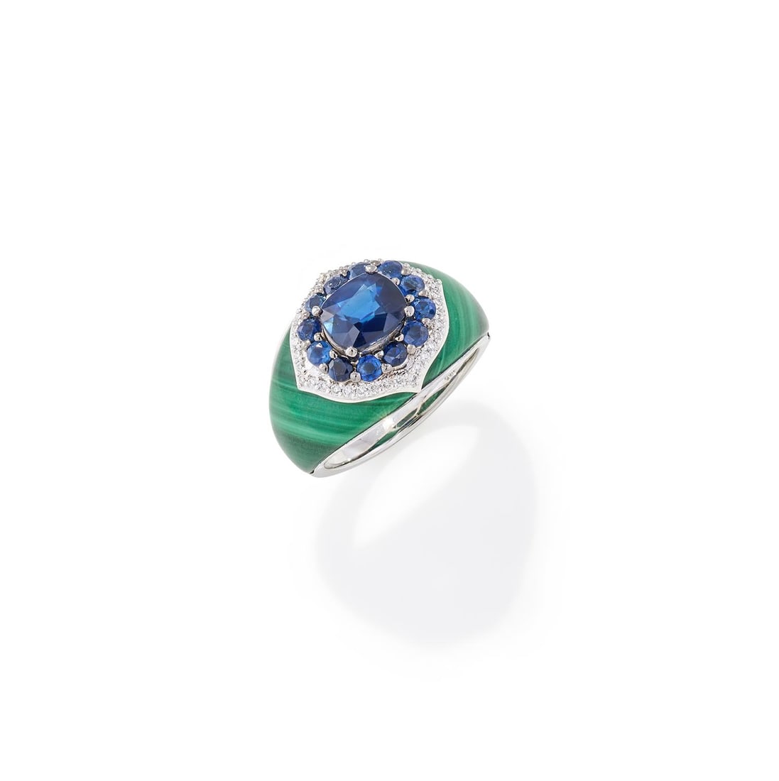 A GEM SET DRESS RING: A GEM SET DRESS RINGDesigned as an oval and circular cut sapphire cluster with a pavé set diamond frame, mounted on a tapered malachite band, stamped PT950Size/dimensions: ring size OGross weight