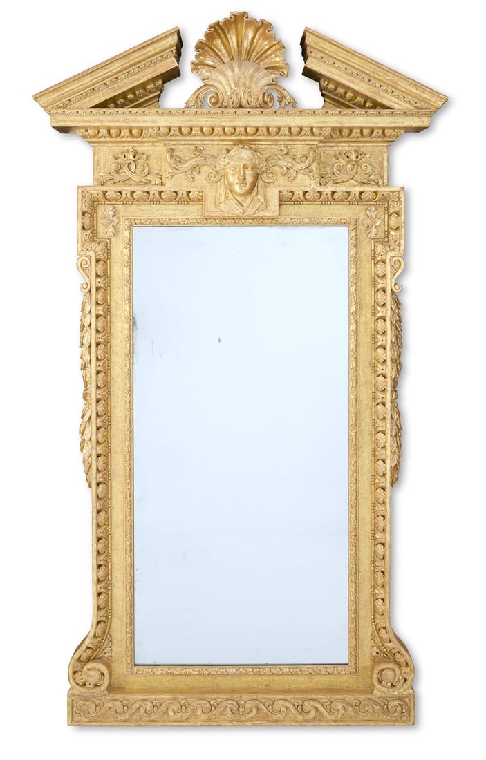 ‡ A GEORGE II CARVED GILTWOOD MIRROR, CIRCA 1740: ‡ A GEORGE II CARVED GILTWOOD MIRRORIN THE MANNER OF WILLIAM KENT, AFTER A DESIGN BY WILLIAM JONES, CIRCA 1740The broken foliate and egg-and-dart pediment centred by a shell above a frieze with a dr