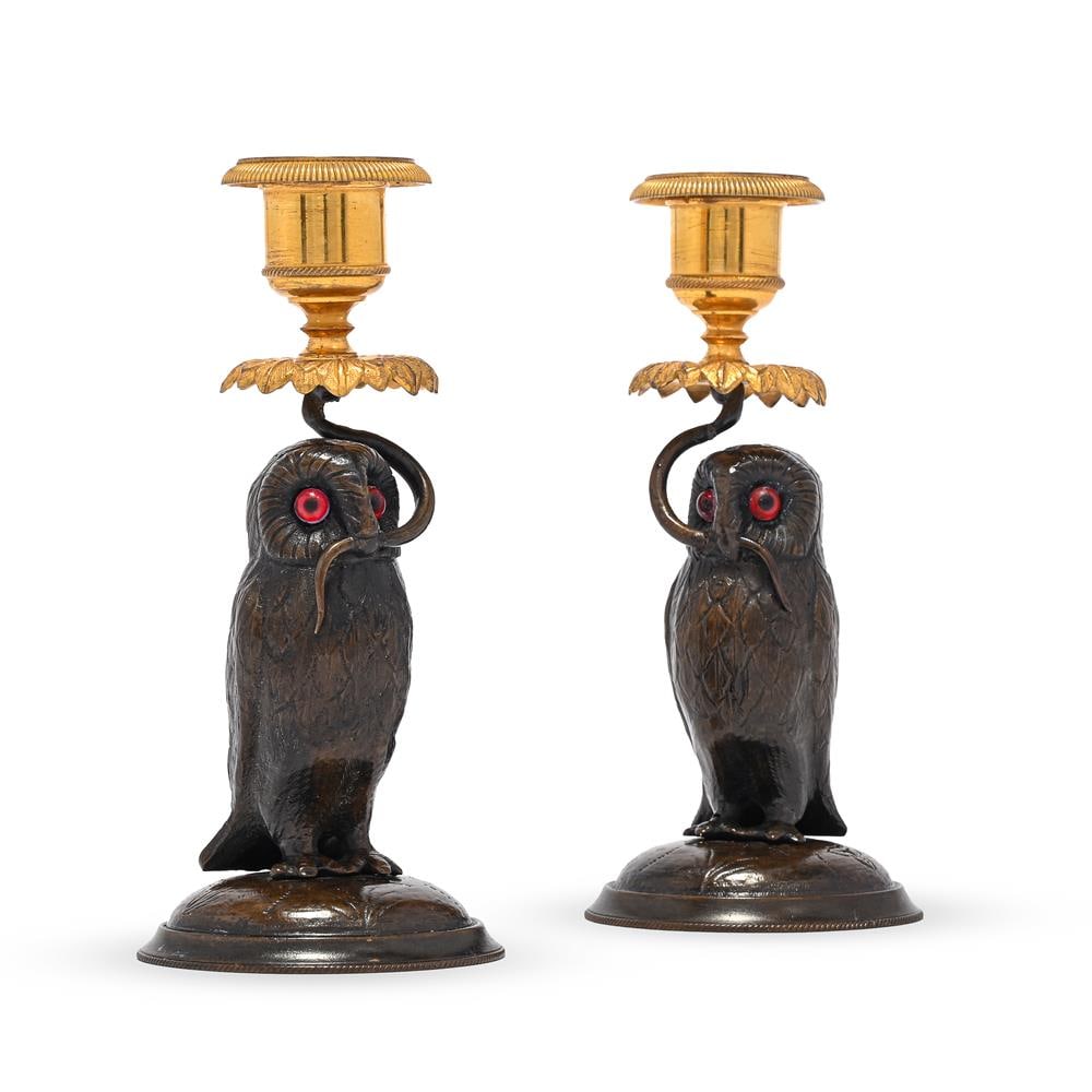 A PAIR OF CONTINENTAL PATINATED AND GILT BRONZE OWL CANDLESTICKS, LATE 19TH OR EARLY 20TH CENTURY: A PAIR OF CONTINENTAL PATINATED AND GILT BRONZE OWL CANDLESTICKS