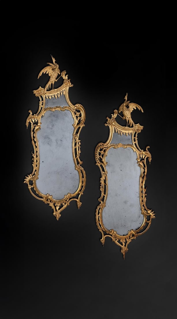 A FINE PAIR OF EARLY GEORGE III CARVED GILTWOOD MIRROR, IN THE MANNER OF THOMAS JOHNSON, CIRCA 1765: A FINE PAIR OF EARLY GEORGE III CARVED GILTWOOD MIRRORIN THE MANNER OF THOMAS JOHNSON, CIRCA 1765145cm high, 57cm wideThomas Johnson published a 'Collection of Designs' in 1758 and 'One Hundred and Fi