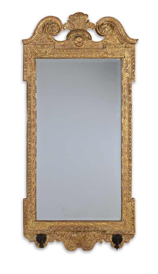 A GEORGE II CARVED GILTWOOD GIRANDOLE MIRROR, IN THE MANNER OF WILLIAM KENT, CIRCA 1740: A GEORGE II CARVED GILTWOOD GIRANDOLE MIRRORIN THE MANNER OF WILLIAM KENT, CIRCA 1740With two brass sconces for candle arms130cm high, 62cm wide
