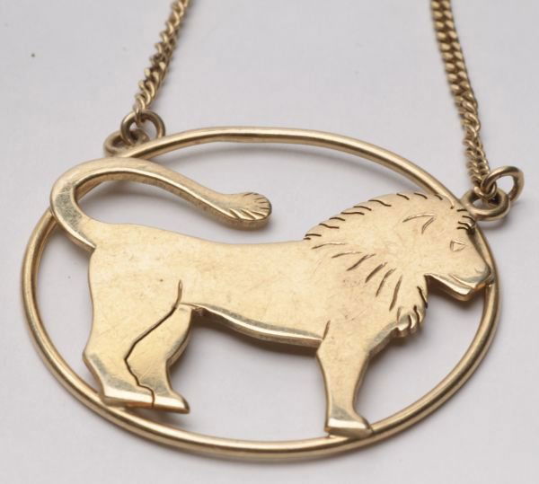 A 9 carat gold Leo zodiac pendant on a chain, Lond: A 9 carat gold Leo zodiac pendant on a chain, London import mark for 1998, the cut out and part engraved big cat within an oval frame, 3.5cm across, on a filed curb link chain, 46cm long, 10.5g gross