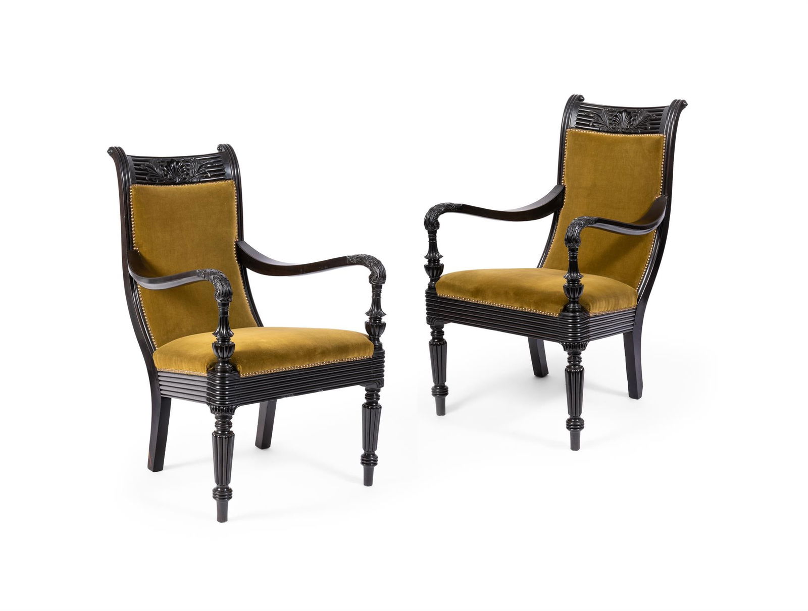 Y A PAIR OF CEYLONESE SOLID EBONY AND UPHOLSTERED ARMCHAIRS, 19TH CENTURY: Y A PAIR OF CEYLONESE SOLID EBONY AND UPHOLSTERED ARMCHAIRS SRI LANKA, 19TH CENTURYEach with reeded and foliate-carved frames, the curved toprails each centred by a shell, on tapering turned and