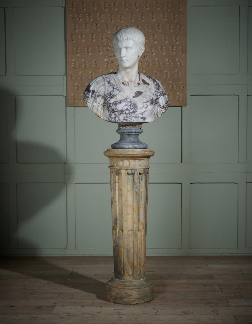 AFTER THE ANTIQUE, A LARGE ITALIAN MARBLE BUST OF CALIGULA ON PEDESTAL, PROBABLY EARLY 20TH CENTURY: AFTER THE ANTIQUE, A LARGE ITALIAN MARBLE BUST OF CALIGULA ON PEDESTAL PROBABLY EARLY 20TH CENTURY White marble head in variegated Arabascato marble shoulders, titled to socle base Caligola, on a flut