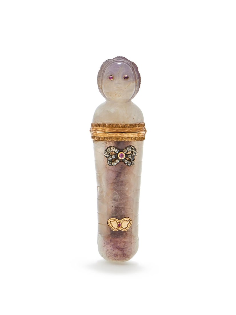 AN 18TH CENTURY AMETHYST AND RUBY ETUI: AN 18TH CENTURY AMETHYST AND RUBY ETUICIRCA 1780Modelled as a swaddled infant, with foiled cabochon ruby eyes, with an applied facetted white stone and ruby bow with push button, and ruby accented pan
